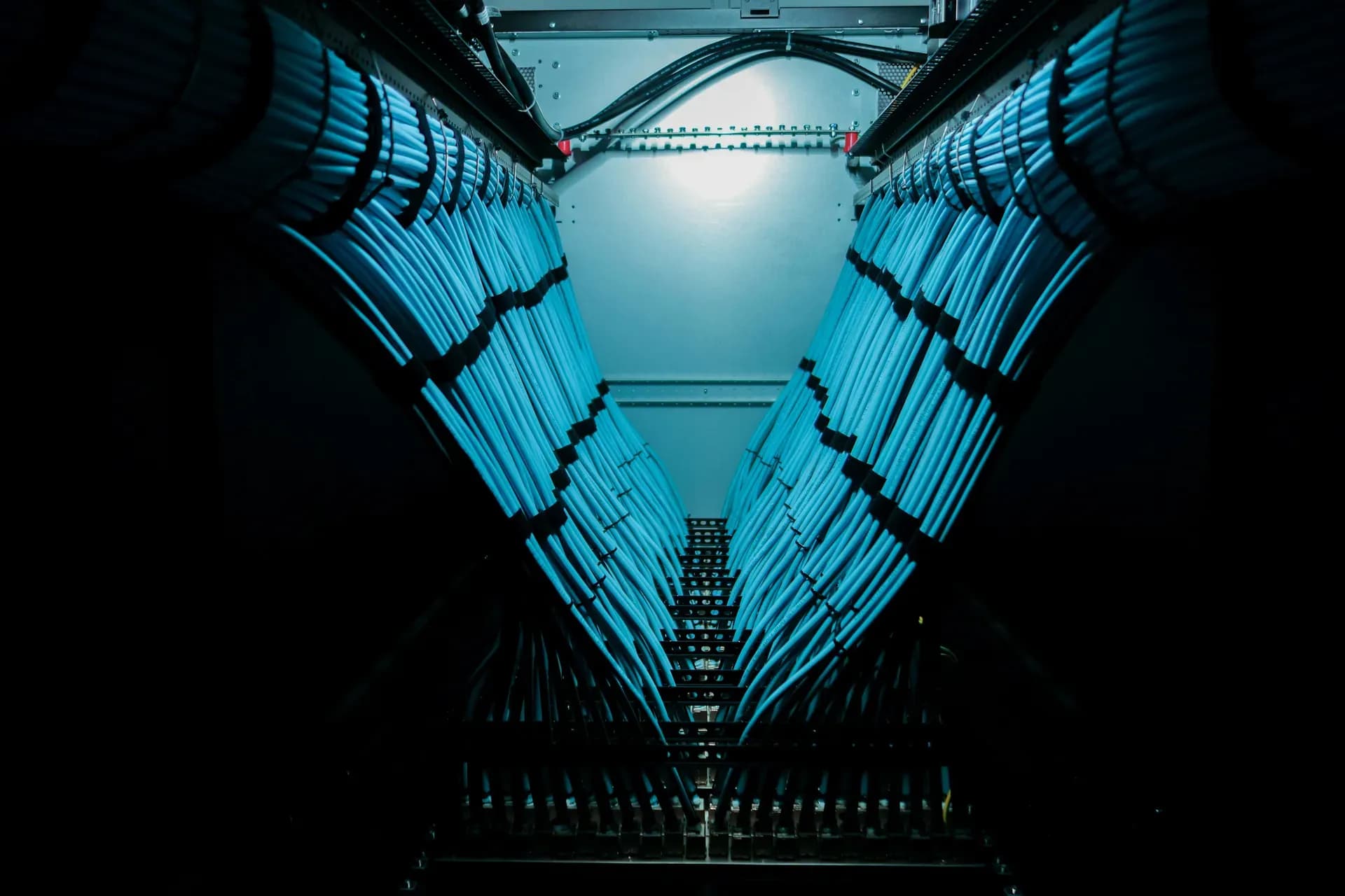 Corridoio di un data center con i fasci di cavi che convergono verso il fondo