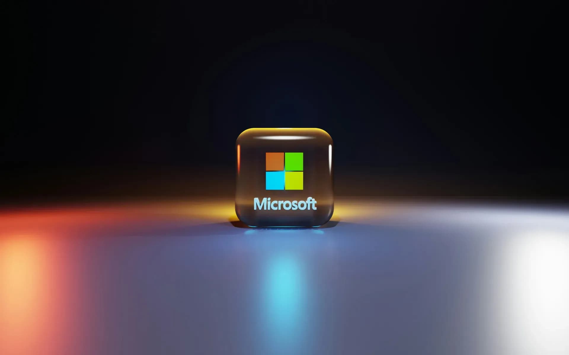 Logo Microsoft su una tessera tridimensionale illuminata, appoggiata su una superficie scura